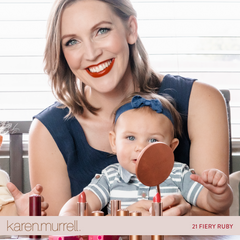 mother wearing red lipstick while holding baby 